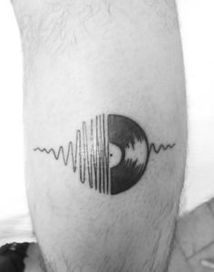 a black and white photo of a man's head with a wave tattoo on it