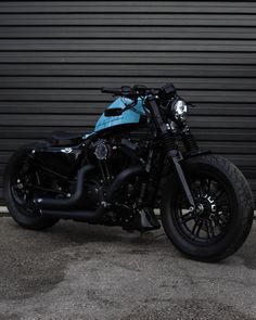 a black and blue motorcycle parked in front of a garage door