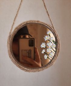 a person taking a selfie in front of a mirror with daisies on it