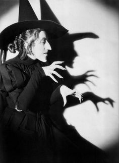 a woman wearing a witches hat and holding her hands out in front of the camera