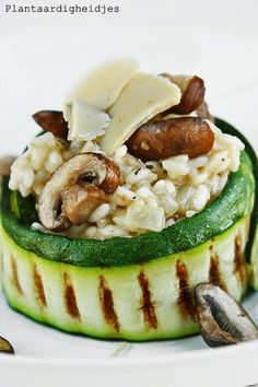 a cucumber topped with rice and mushrooms on a white plate