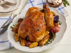 a roasted chicken and potatoes on a white plate