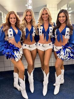 three cheerleaders are posing in the bathroom