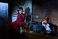 two people sitting at a desk in an office