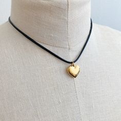 This Black Cord Heart Drop Necklace is a timeless addition to your jewelry collection. Featuring a fashionable black cord chain and dimensional rounded heart pendant, this necklace will be the perfect accent to any outfit. With its versatility and class, it's sure to impress.Dimensions: approximately 16" cord with a 2" extender, heart charm is approximately 0.6" x 0.5"18k gold plated stainless steel, water and tarnish freeLead and Nickel freeMade In: ChinaMaterial Composition: 18k gold plated stainless steel Gold Drop Necklace, Silver Drop Necklace, Black Cord Necklace, Metallic Foil, Cord Necklace, Drop Necklace, Gold Heart, Steel Water, Heart Charm