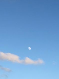 an airplane is flying in the sky with a half moon behind it and some clouds