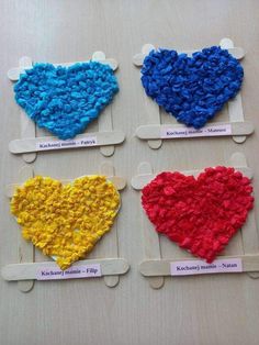 four hearts made out of yarn on wooden pegs with name tags attached to them