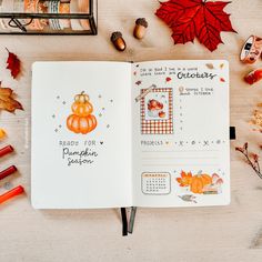 an open planner book with autumn decorations and leaves