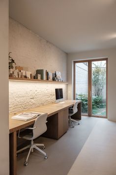 a home office with two desks and an open door that leads to the outside