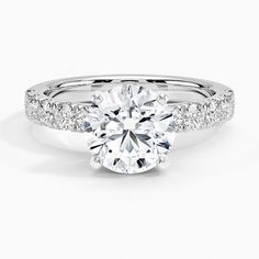 a round cut diamond ring with pave set shoulders