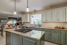 This refresh took some of the kitchen's already nice features (the layout, backsplash, countertops) and updated it to make the client's style even better. 
All cabinet doors, including the cabinetry around the island was all updated. They ended up going with the green for the lower cabinets and the island. For the upper cabinets, they chose a very subtle and lighter shade of green; still drawing in colors from the countertop and tying in the dark green from the lower cabinets. Countertops That Go With Green Cabinets, Green Cabinets With Brown Granite Countertops, Green Kitchen Cabinets Beige Countertop, Green Kitchen Cabinets Wall Color, Granite Countertops With Sage Green Cabinets, Brown Countertops Green Cabinets, Green Kitchen With Granite Countertops, Green Cabinets With Brown Granite