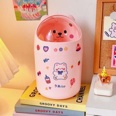 there is a pink bear pot on top of some books