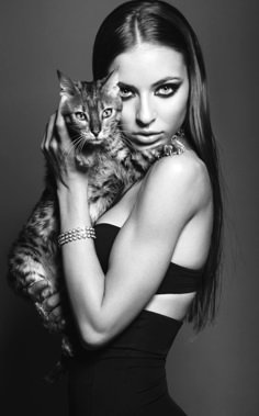 a woman holding a cat in her arms