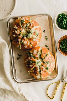 two rolls with cheese and spinach on a tray next to some other food items