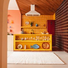 a kitchen with yellow cabinets and white rug on the floor in front of an oven