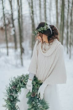 a woman holding a wreath in the snow