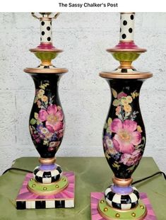 two black and white vases sitting on top of a table next to each other