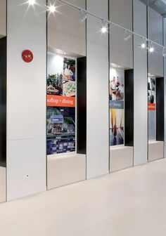 an airport lobby with multiple doors and advertisements on the walls