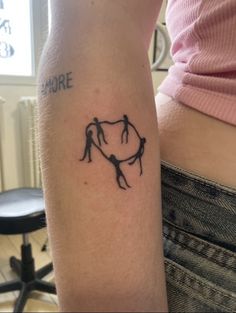 a woman's arm with a tattoo on it that has two people holding hands