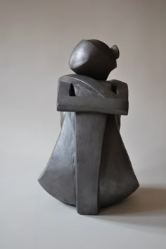 a gray sculpture sitting on top of a white table