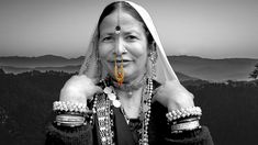 an old woman with beads on her head and necklaces around her neck posing for the camera