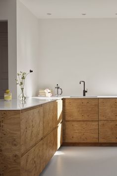 a kitchen with white walls and wooden cabinets