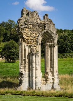 an old stone structure in the middle of a field