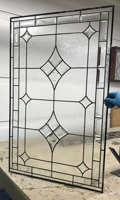 a large stained glass window sitting on top of a counter next to a blue glove