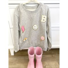 This is the personalized initial chenille patch sweatshirt made to order for your little cutie! The sweatshirt features your little one's first initial, along with four other patches: smiley face, lightning bolt, rainbow and balloon. Perfect for a birthday or the holidays, this super soft sweatshirt will pair well with leggings and boots or dressed up with a tutu! So on trend for the season !                         Choose from a grey or light pink sweatshirt. Washing Instructions: Wash inside o Iron Patch Sweatshirt, Diy Patch Sweatshirt Ideas, Diy Sweatshirt Iron On Patches, Sweatshirt Patches Diy, Chenille Shirt Ideas, Patch Sweatshirt Ideas, Diy Iron On Patches Sweatshirt, Sweatshirts With Patches, Chenille Patch Ideas