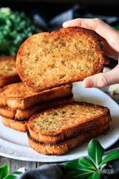 someone is holding up some bread on a plate