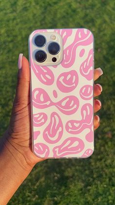 a person holding up a pink and white phone case in front of their face,