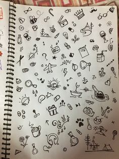 an open notebook with doodles on it and various symbols in the pages next to each other