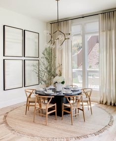 the dining room table is surrounded by chairs and pictures on the wall, along with a chandelier