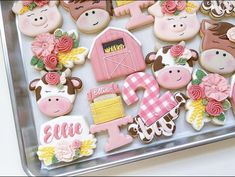 decorated cookies in the shape of farm animals and barnyards on a baking sheet