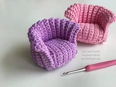 two crocheted baskets sitting on top of a table next to a knitting needle