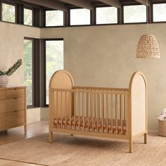 a baby's room with a crib, dressers and other furniture in it