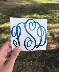 someone holding up a sticker with the letter s on it