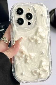 a person holding an iphone case with white flowers on the front and back cover in clear plastic