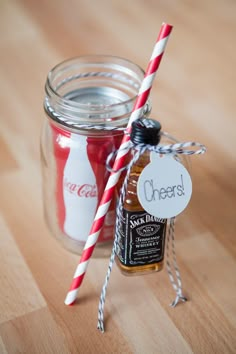 a glass jar with some candy in it and two straws sticking out of the top