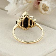 a gold ring with black stones on it