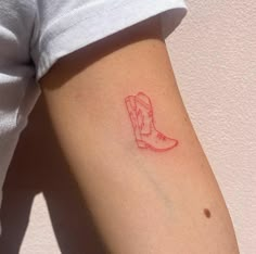 a small red boot tattoo on the left upper arm and right lower arm, which has a line drawing of a cowboy's boot