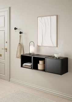 a white room with two black shelves and a mirror on the wall next to it