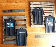 some t - shirts are hanging on wooden pallets