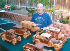 a man standing in front of wooden toy cars