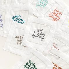 six embroidered napkins with words on them