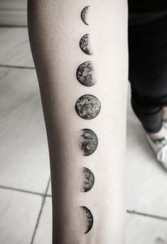 a woman's arm with phases of the moon on it