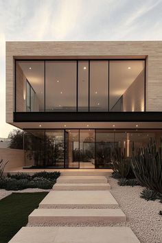 an exterior view of a modern house with stone steps leading up to the front door