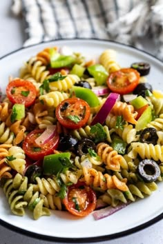 a white plate filled with pasta salad on top of a table