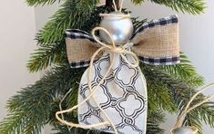 an ornament hanging from a christmas tree decorated with burlock and ribbon