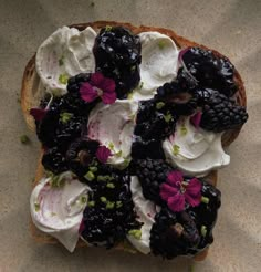 a piece of bread topped with whipped cream and blackberries